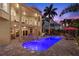 Beautiful outdoor pool and living space with lush landscaping and ambient lighting at 6015 Kipps Colony E Dr, Gulfport, FL 33707