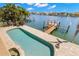 Backyard pool and private dock on the water, surrounded by lush tropical landscaping at 6015 Kipps Colony E Dr, Gulfport, FL 33707
