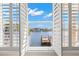 Inviting window view of a private dock on the water with bright blue skies and white clouds overhead at 6015 Kipps Colony E Dr, Gulfport, FL 33707