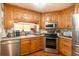 Traditional kitchen featuring oak cabinets, stainless steel appliances and hardwood floors at 6726 S Sheridan Rd, Tampa, FL 33611