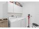 Clean laundry room with washer, dryer, and cabinets at 8280 Rolling Tides Dr, New Port Richey, FL 34655