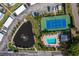 Aerial view of tennis court, pool, and pond at 9386 Tradewinds Ave, Seminole, FL 33776