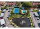 Aerial view of community pool, tennis court, and pond at 9386 Tradewinds Ave, Seminole, FL 33776