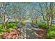 Scenic community pathway with benches under a canopy of trees for peaceful relaxation and reflection at 9418 W Park Village Dr # 105, Tampa, FL 33626