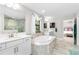 Bright bathroom features a soaking tub, double sinks, and a separate glass enclosed shower for spa-like tranquility at 14672 Horse Trot Rd, Lithia, FL 33547