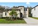 Beautiful two-story home with a well-manicured lawn and tasteful landscaping, including small palm trees at 14672 Horse Trot Rd, Lithia, FL 33547