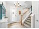 Bright foyer with wood floors, staircase, and decorative chandelier create a welcoming entrance at 14672 Horse Trot Rd, Lithia, FL 33547