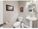 Elegant powder room featuring a pedestal sink, decorative mirror, and charming wall art at 1957 Whitney Oaks Blvd, Clearwater, FL 33760