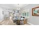 Dining room with a glass table, modern chandelier, and view of the staircase at 1957 Whitney Oaks Blvd, Clearwater, FL 33760