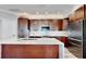 Kitchen features dark wood cabinets with a large island and stainless steel appliances at 1957 Whitney Oaks Blvd, Clearwater, FL 33760