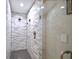 Stylish walk-in shower with gray-veined tile, glass doors, and a rain shower head at 1957 Whitney Oaks Blvd, Clearwater, FL 33760
