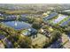 Stunning aerial view of the community highlighting the pool, tennis courts, and tranquil lake at 201 Silver Lake Dr # 204, Venice, FL 34292