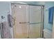 Bathroom featuring a walk-in shower with grab bar, white tile, and glass sliding doors with a towel rack at 201 Silver Lake Dr # 204, Venice, FL 34292