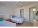 Bedroom with two twin beds, closet, and attached bathroom. Neutral decor and a ceiling fan for comfort at 201 Silver Lake Dr # 204, Venice, FL 34292