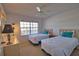 Bedroom featuring two twin beds, neutral carpet, ceiling fan, and a window with water views at 201 Silver Lake Dr # 204, Venice, FL 34292