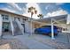 Condo exterior featuring covered parking, stairs, palm trees, and well-maintained landscaping at 201 Silver Lake Dr # 204, Venice, FL 34292