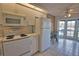 Kitchen features white appliances, a breakfast nook with bright windows, and tile flooring at 201 Silver Lake Dr # 204, Venice, FL 34292