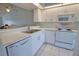 Bright kitchen with white cabinets, a breakfast bar overlooking the living area, and tile floors at 201 Silver Lake Dr # 204, Venice, FL 34292
