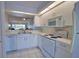 Modern kitchen featuring white appliances, a breakfast bar, and an open view to the living area at 201 Silver Lake Dr # 204, Venice, FL 34292