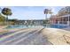 Community pool with lounge chairs and a clubhouse surrounded by lush greenery with palm trees at 201 Silver Lake Dr # 204, Venice, FL 34292