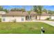 Single-story house with brown roof, light walls, and a well-maintained lawn at 23315 Charlston Pl, Land O Lakes, FL 34639