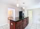 Kitchen features a large island with granite countertop and dark wood cabinets at 23315 Charlston Pl, Land O Lakes, FL 34639