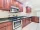 Kitchen with stainless steel appliances and dark wood cabinets at 23315 Charlston Pl, Land O Lakes, FL 34639