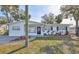 Charming single-story home with a landscaped front yard and black trimmed windows, complete with an American flag at 4116 Ohio Ave, Tampa, FL 33616