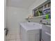 Functional laundry room equipped with a washer, dryer, and storage shelf at 4116 Ohio Ave, Tampa, FL 33616