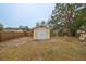 A backyard shed for extra storage with double doors and a neutral paint scheme is surrounded by a fenced yard at 4116 Ohio Ave, Tampa, FL 33616