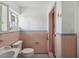 Pink tiled bathroom with toilet, sink, and shower, ready for updates at 529 80Th Ave, St Pete Beach, FL 33706