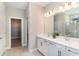 Elegant bathroom with double vanity, white cabinets, and a walk-in shower at 7122 Heron Walk Ln, Wesley Chapel, FL 33545