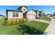 One-story house with tan siding, stone accents, and a two-car garage at 7122 Heron Walk Ln, Wesley Chapel, FL 33545