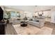 Open-concept living area showcases a large gray sofa, and seamlessly connects to the kitchen area at 7122 Heron Walk Ln, Wesley Chapel, FL 33545