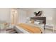 Spacious bedroom with a gray headboard, orange bedding, and a comfortable armchair at 10911 Gentle Current Way, Parrish, FL 34219