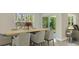 Light and bright dining room with a wood table and six chairs, adjacent to the kitchen at 10911 Gentle Current Way, Parrish, FL 34219