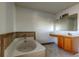 Bathroom with a garden tub, wood vanity, and tile flooring at 11309 Outrigger Ave, Spring Hill, FL 34608