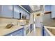 Small galley kitchen with blue cabinets and stainless steel appliances at 1898 Shore Dr S # 317, South Pasadena, FL 33707