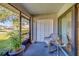 Screened porch with wicker chair and storage closet at 2035 Nash Dr, Clearwater, FL 33763