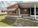 Exterior angle view of home, awning, adjacent patio, and landscaped yard at 225 N Saint Thomas Cir, Apollo Beach, FL 33572