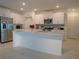 Modern kitchen with white cabinets, stainless steel appliances, and an island at 22547 Storybook Cabin Way, Land O Lakes, FL 34637