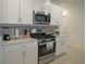 Modern kitchen with white cabinets, stainless steel appliances, and a gas stove at 22547 Storybook Cabin Way, Land O Lakes, FL 34637