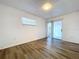 A light bedroom with wood-look floors, white walls, a window and glass sliding doors create a relaxing retreat at 22702 Penny Loop, Land O Lakes, FL 34639