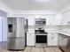 Bright kitchen with stainless steel appliances, white cabinetry, and hardwood floors at 22702 Penny Loop, Land O Lakes, FL 34639