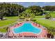 Community pool with surrounding patio furniture and golf course view at 3309 Lori Ln, New Port Richey, FL 34655