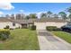 Front view of a villa with a two-car garage, landscaping, and driveway at 3309 Lori Ln, New Port Richey, FL 34655