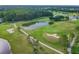 Aerial view of a serene golf course with a pond and walking paths at 3309 Lori Ln, New Port Richey, FL 34655