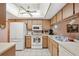 Full view of kitchen with white appliances and light cabinets at 3309 Lori Ln, New Port Richey, FL 34655