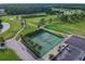 Aerial view of two tennis courts within a lush green golf course community at 3309 Lori Ln, New Port Richey, FL 34655