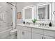Modern bathroom with dual sinks, sleek vanity, illuminated mirrors, and a marble-tiled shower and tub at 600 3Rd S Ave # 401, St Petersburg, FL 33701